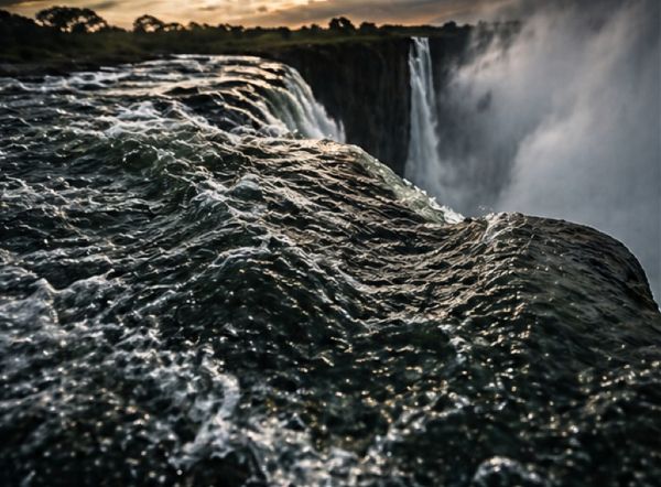 Powerful river current speeding toward the edge of a cliff before plunging down