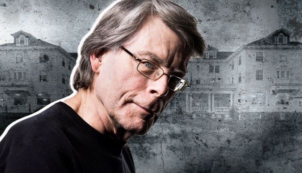 Stephen King sitting in a dark atmospheric library surrounded